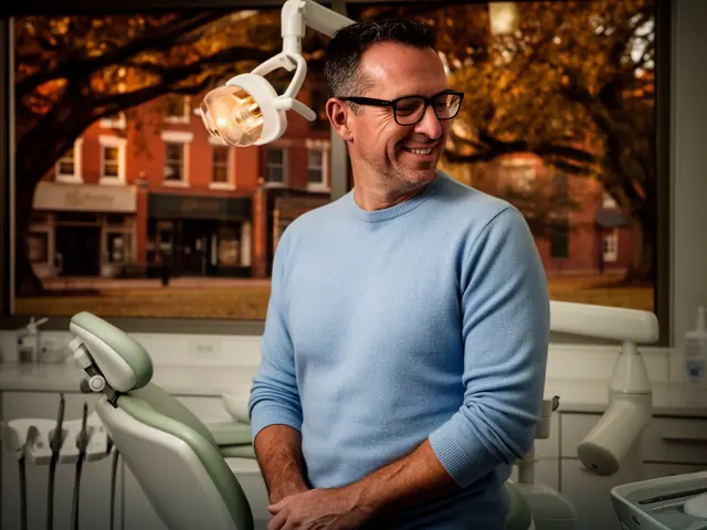 A dentist standing beside a dental chair.